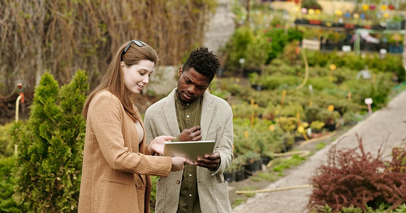 Female Landscaper Showing Customer Plans on Tablet