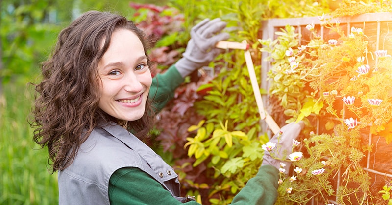 Female landscaper smiling and working on flowers