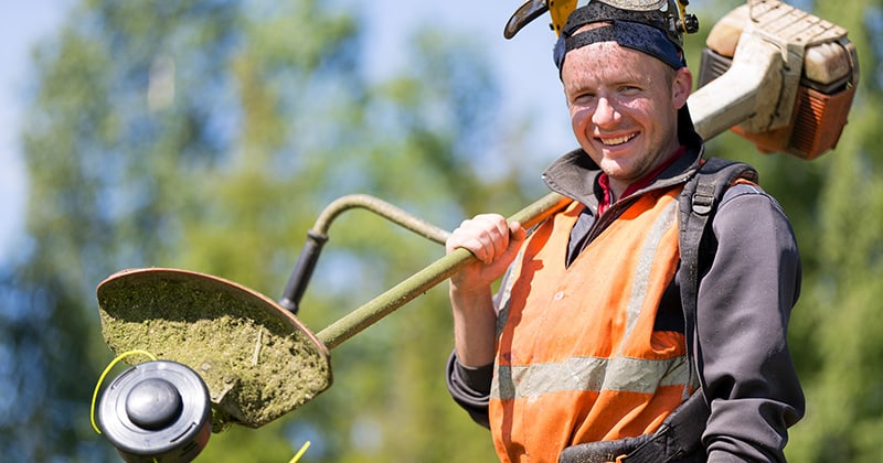 Landscape Employee Smiling and Holding an Edger.