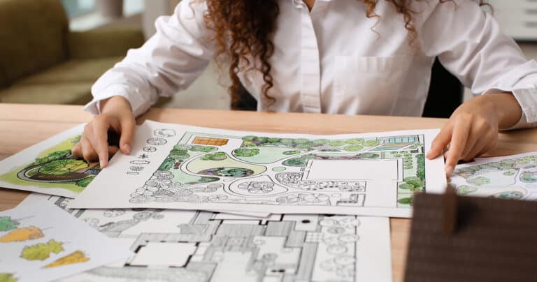 Woman looking at her paper landscape designs