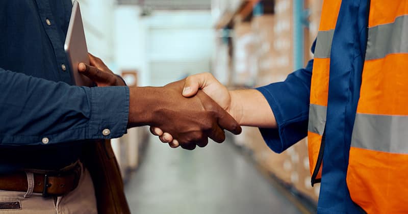 employer-skaing-hands-with-man-in-orange-vest