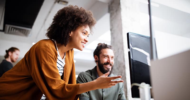 lady-helping-man-on-computer-and-training