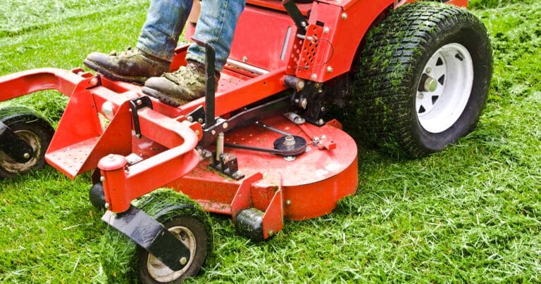 employee-mowing-lawn-on-red-mower